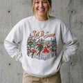 Model wearing Let It Snow Christmas Sweatshirt against a cement wall