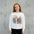 Model wearing Christmas Reindeer and Gnome Sweatshirt against a cement wall