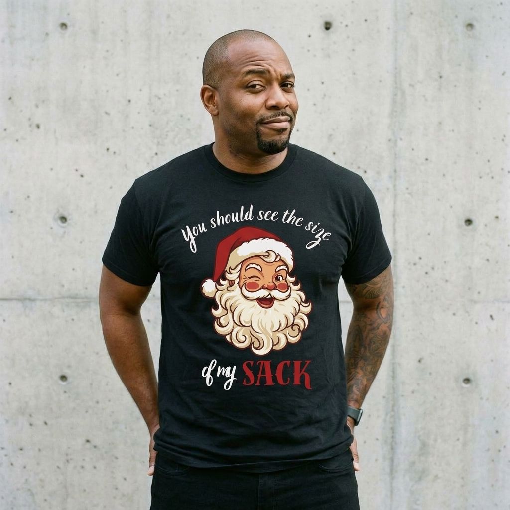 Model wearing Santa 'You Should See the Size of My Sack' Christmas Tee against a cement wall