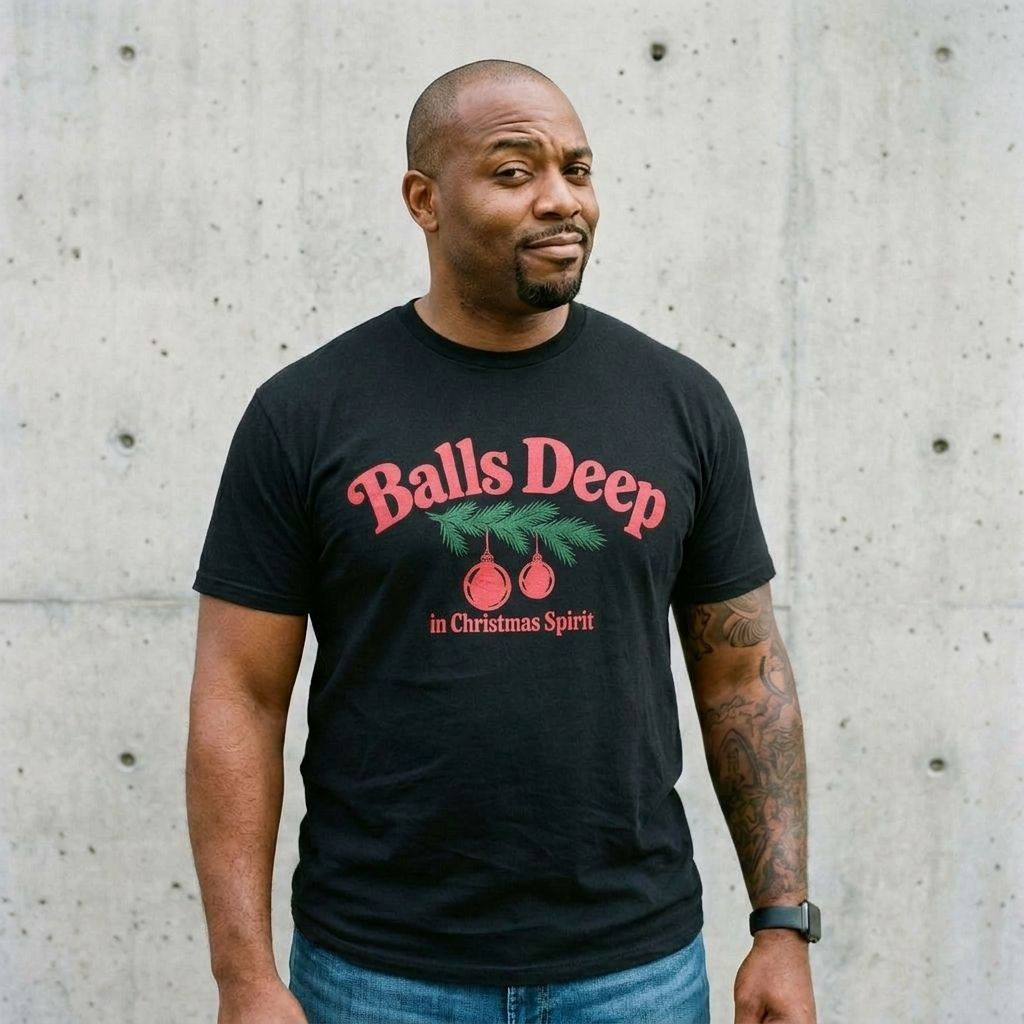 Model wearing Balls Deep Christmas Tee against a cement wall