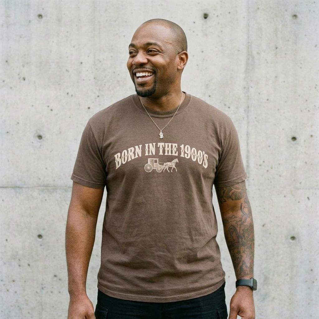 Model wearing Born in the 1900s Graphic Tee against a cement wall