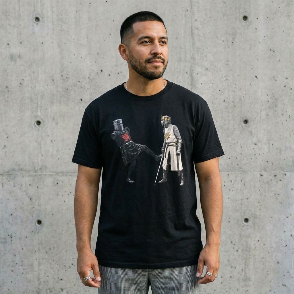 Model wearing M Python & The Holy Grail Black Knight Tee against a cement wall