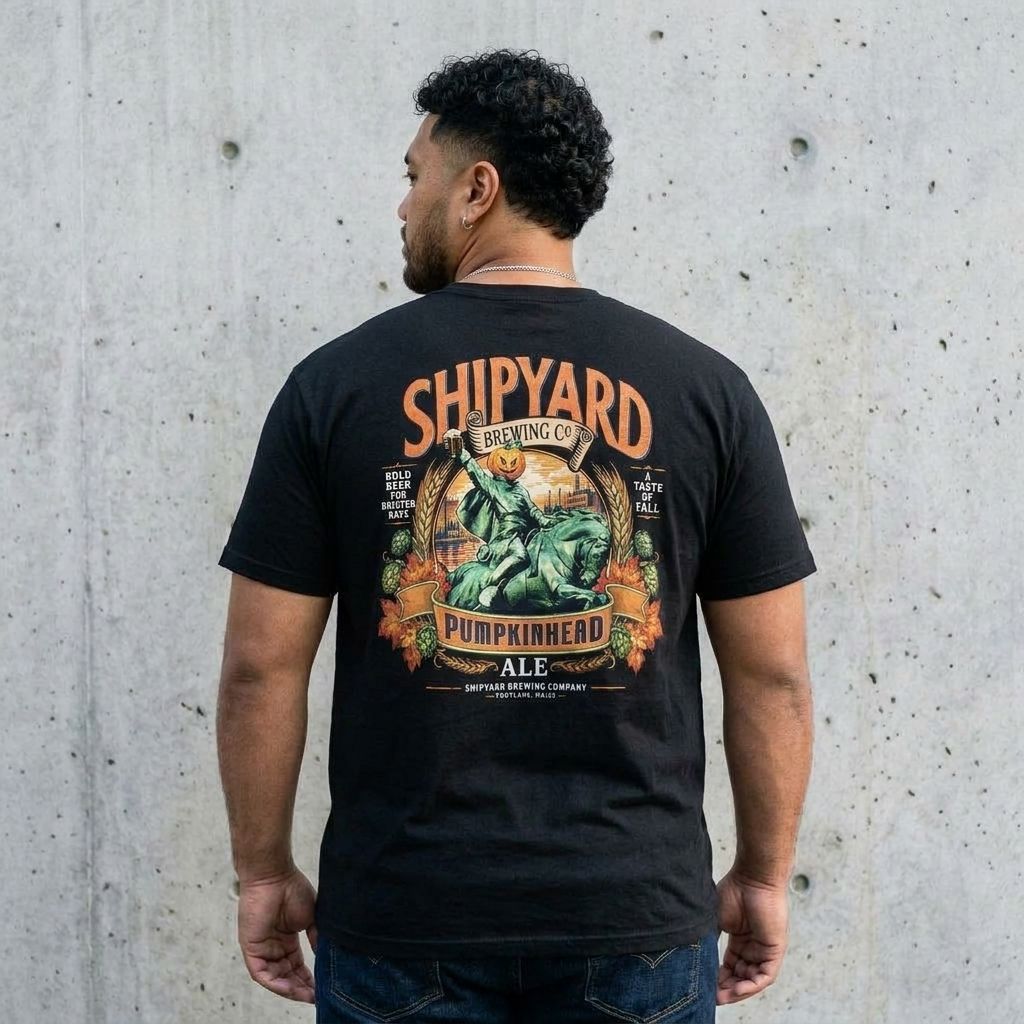 Back view of model wearing Pumpkinhead Ale Tee against a cement wall