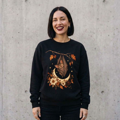Model wearing Autumn Bat Moon Sweatshirt against a cement wall