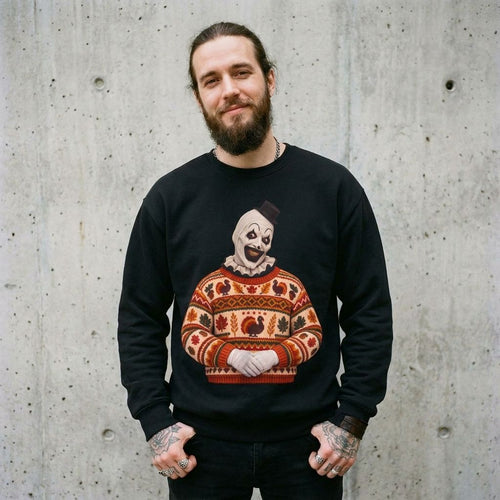 Man wearing the Art the Clown Thanksgiving horror sweatshirt in black against a cement wall