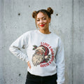 Woman wearing the I Love a Man with a Beard Santa Christmas sweatshirt against a cement wall