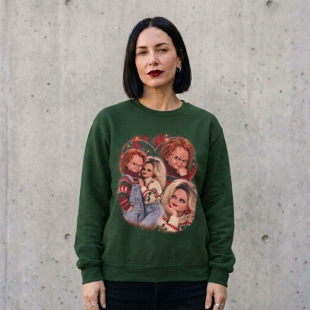 Woman wearing the Chucky and Tiffany 80s glamour portrait horror Christmas sweatshirt against a cement wall