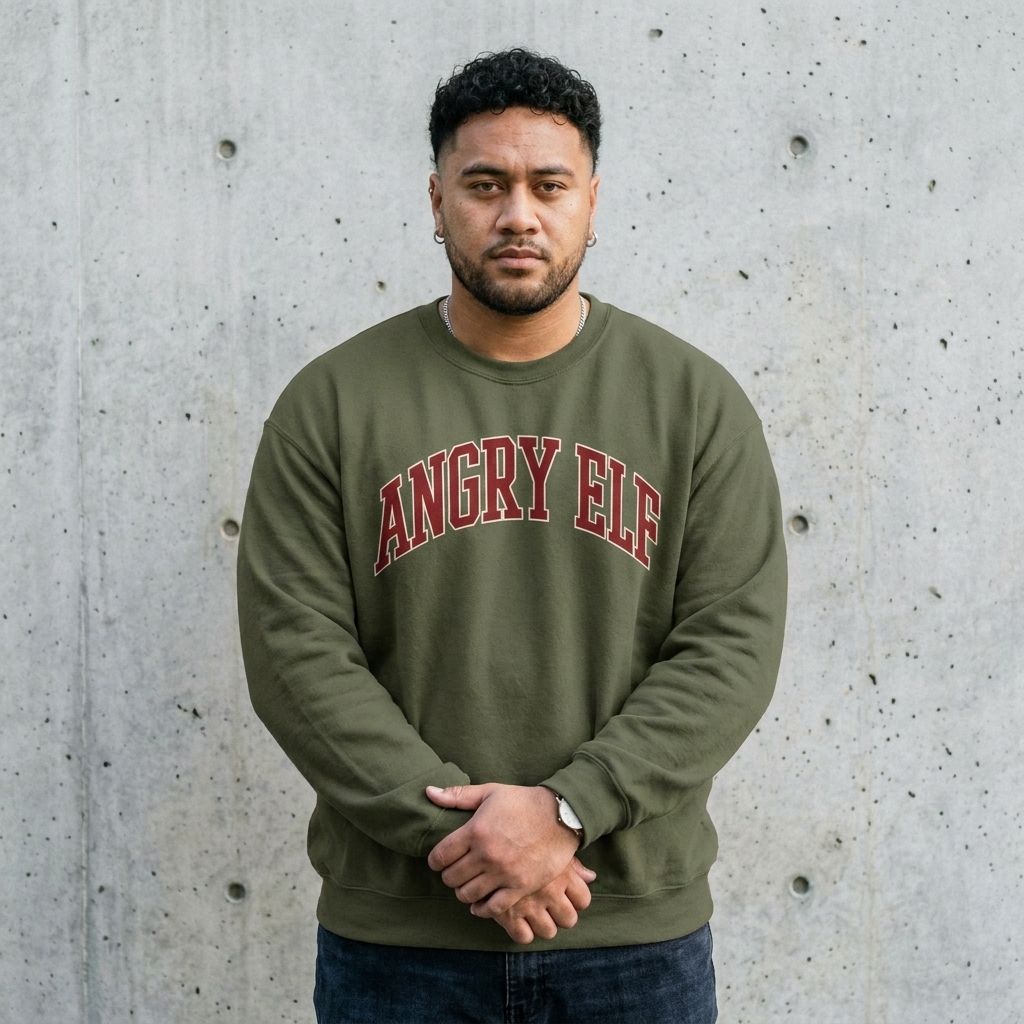 Man wearing the Angry Elf funny Christmas sweatshirt against a cement wall