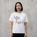 Woman wearing the Stick Figure Murder dark humor t-shirt against a cement wall