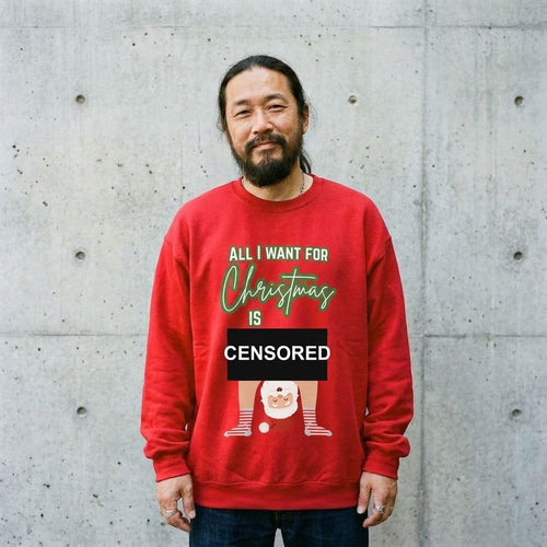 Man wearing the All I Want for Christmas Is You Santa couples sweatshirt against a cement wall