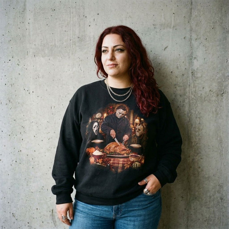 Model wearing the Michael Myers, Ghostface and Jason Thanksgiving sweatshirt in Black against a cement wall