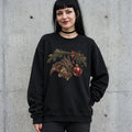 Woman wearing the gothic Christmas bat sweatshirt against a cement wall