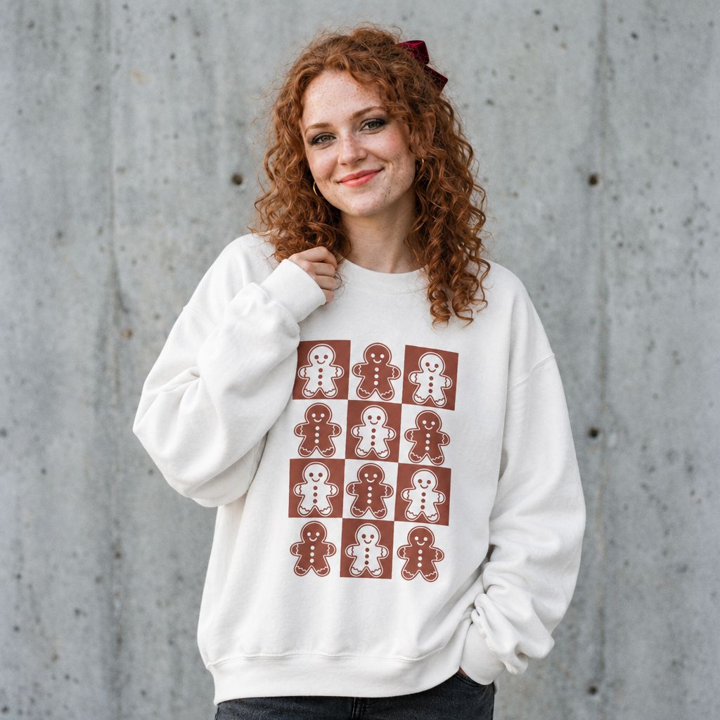 Woman wearing the gingerbread Christmas sweatshirt against a cement wall