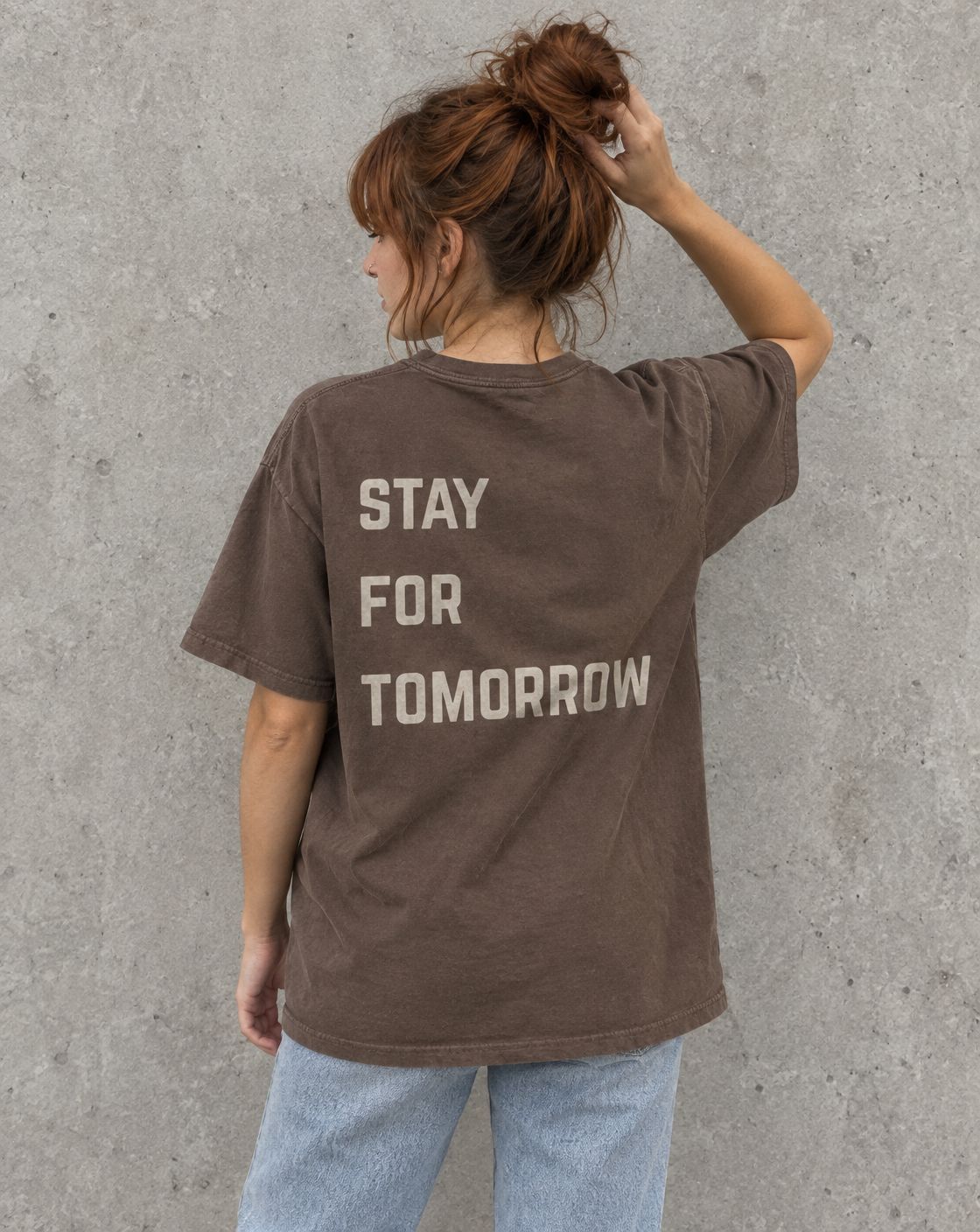 Model wearing the espresso Stay for Tomorrow suicide awareness t-shirt, back view
