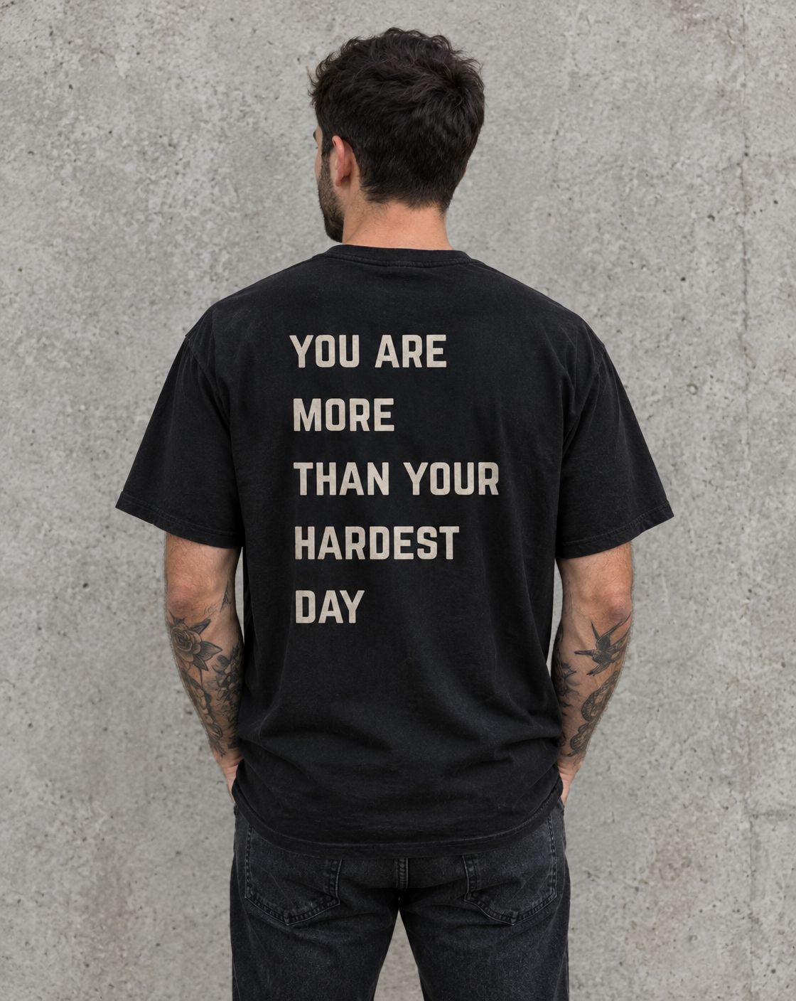 Model wearing the black You Are More Than Your Hardest Day suicide awareness t-shirt, back view