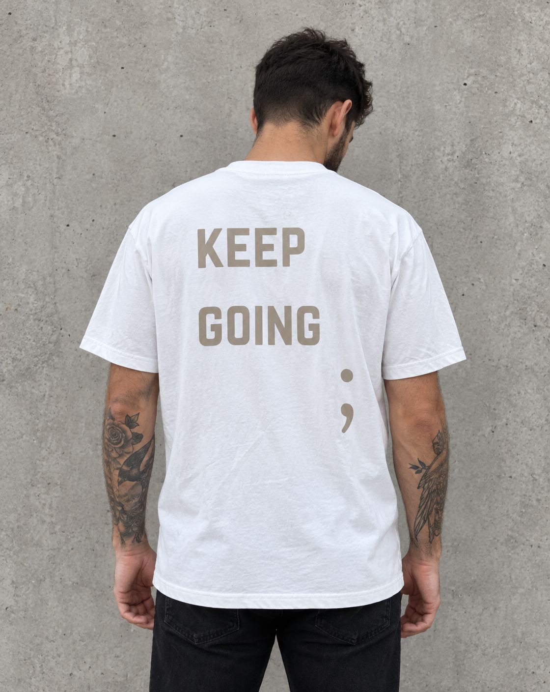 Model wearing the white Keep Going semicolon suicide awareness t-shirt, back view