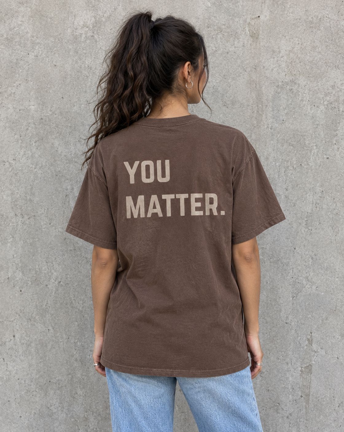 Model wearing the espresso You Matter. suicide awareness t-shirt, back view