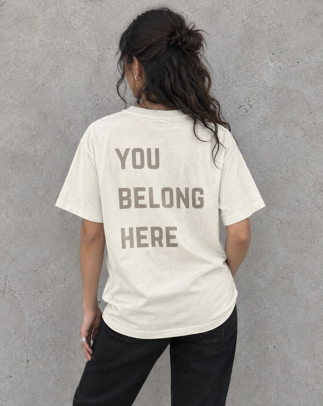 Model wearing the ivory You Belong Here suicide awareness t-shirt, back view