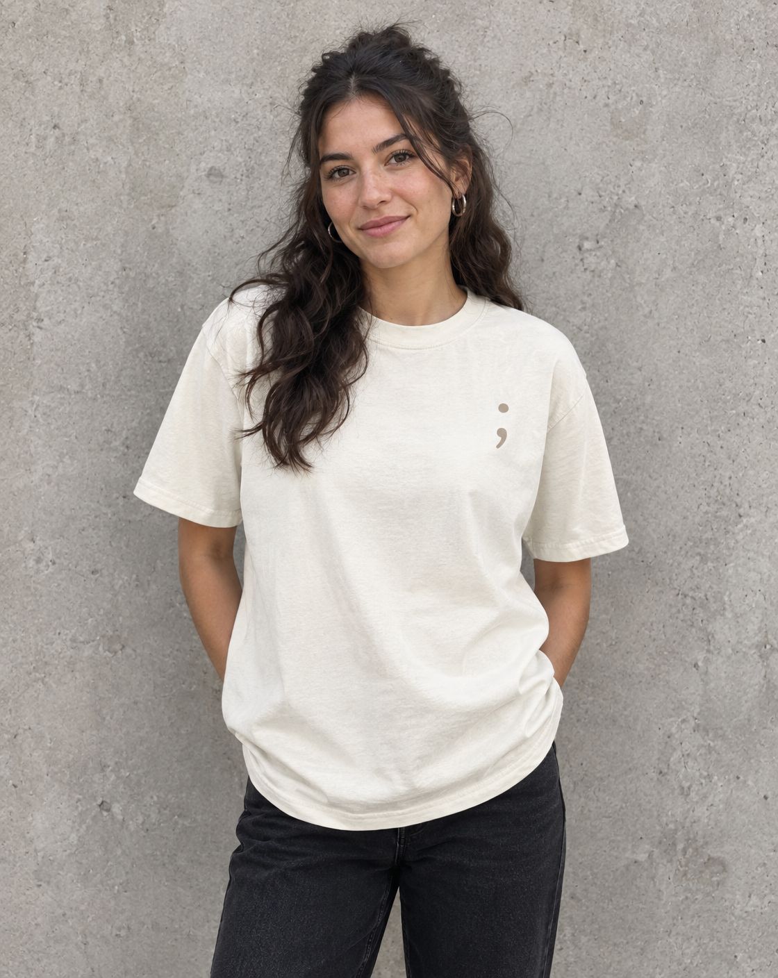 Model wearing the ivory You Belong Here t-shirt, front view with small semicolon