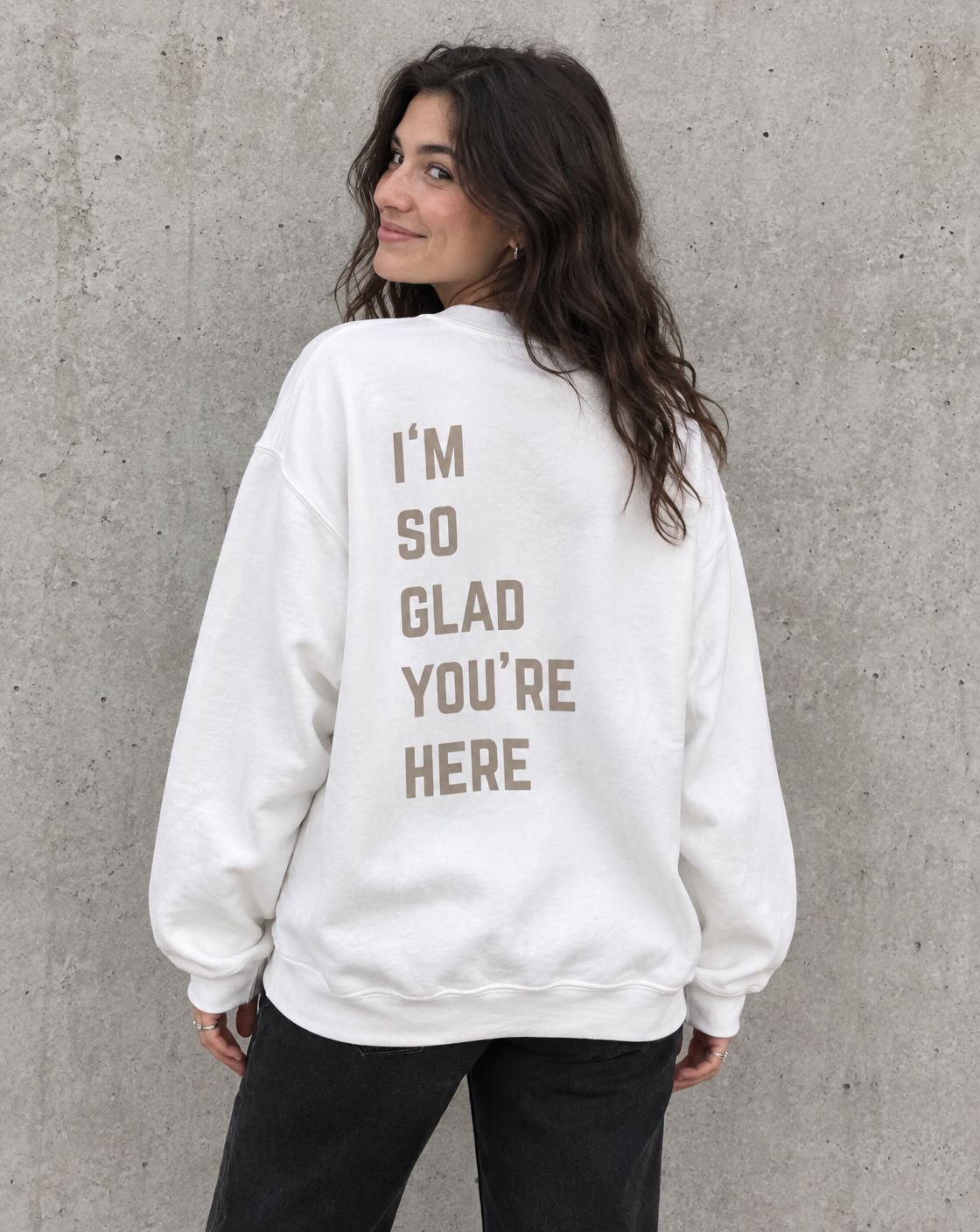 Model wearing the white I'm So Glad You're Here suicide awareness crewneck sweatshirt, back view