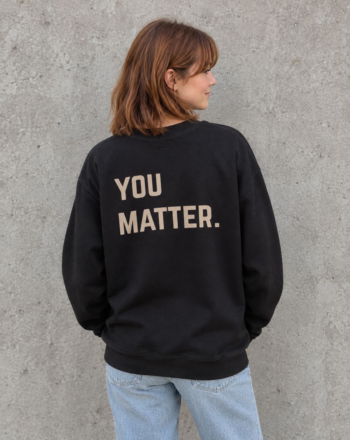 Model wearing the black You Matter. suicide awareness crewneck sweatshirt, back view