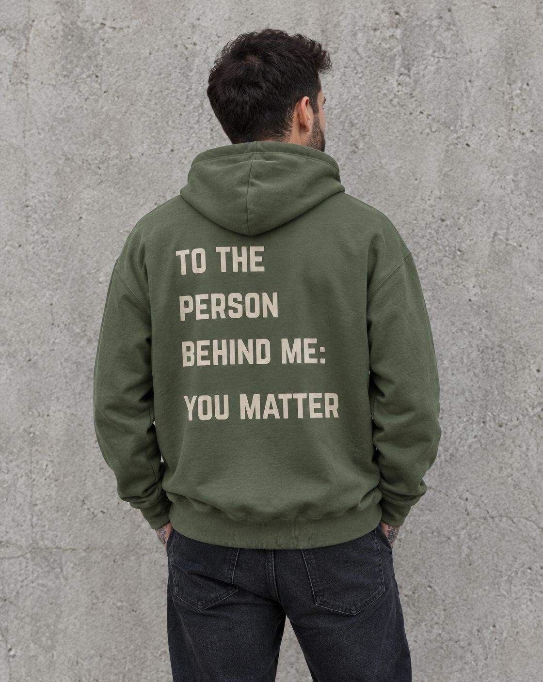 Model wearing the military green To the Person Behind Me, You Matter suicide awareness pullover hoodie, back view