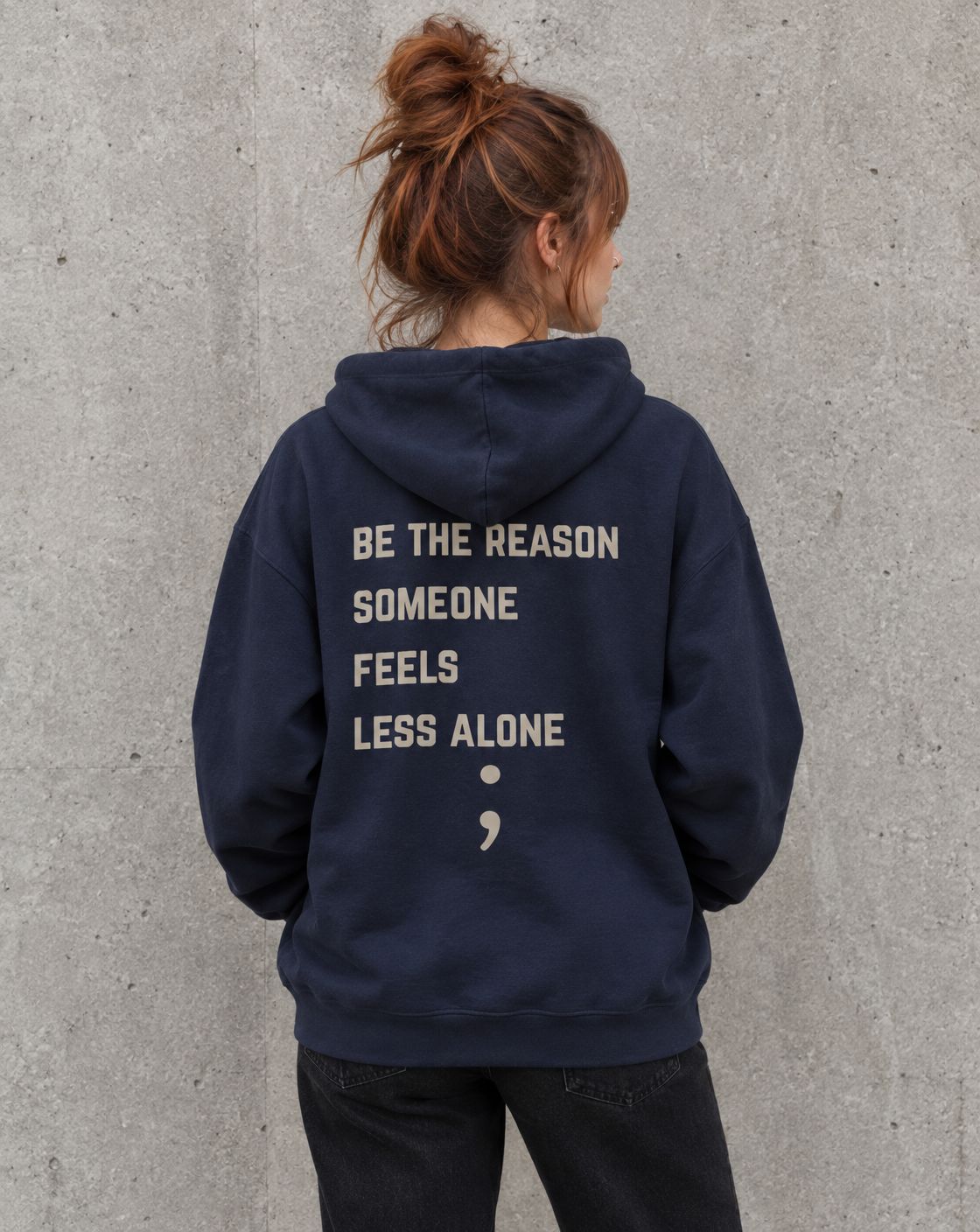Model wearing the navy Be the Reason Someone Feels Less Alone suicide awareness pullover hoodie, back view