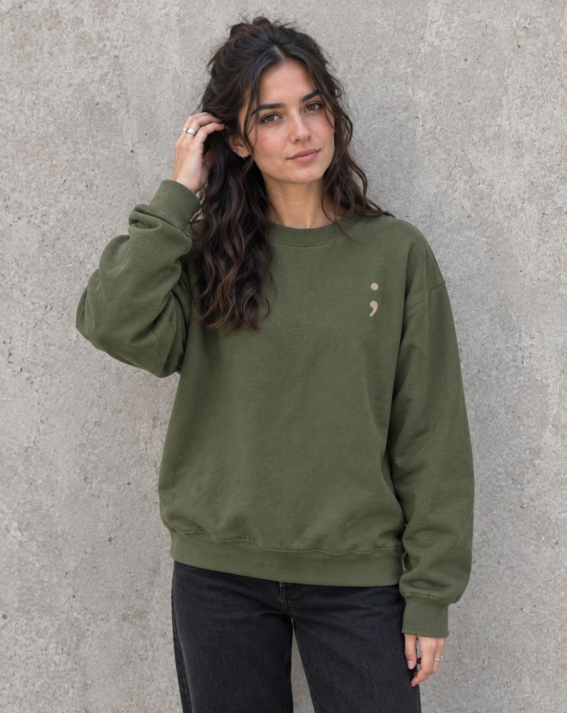 Model wearing the military green Please Stay; crewneck sweatshirt, front view with small semicolon
