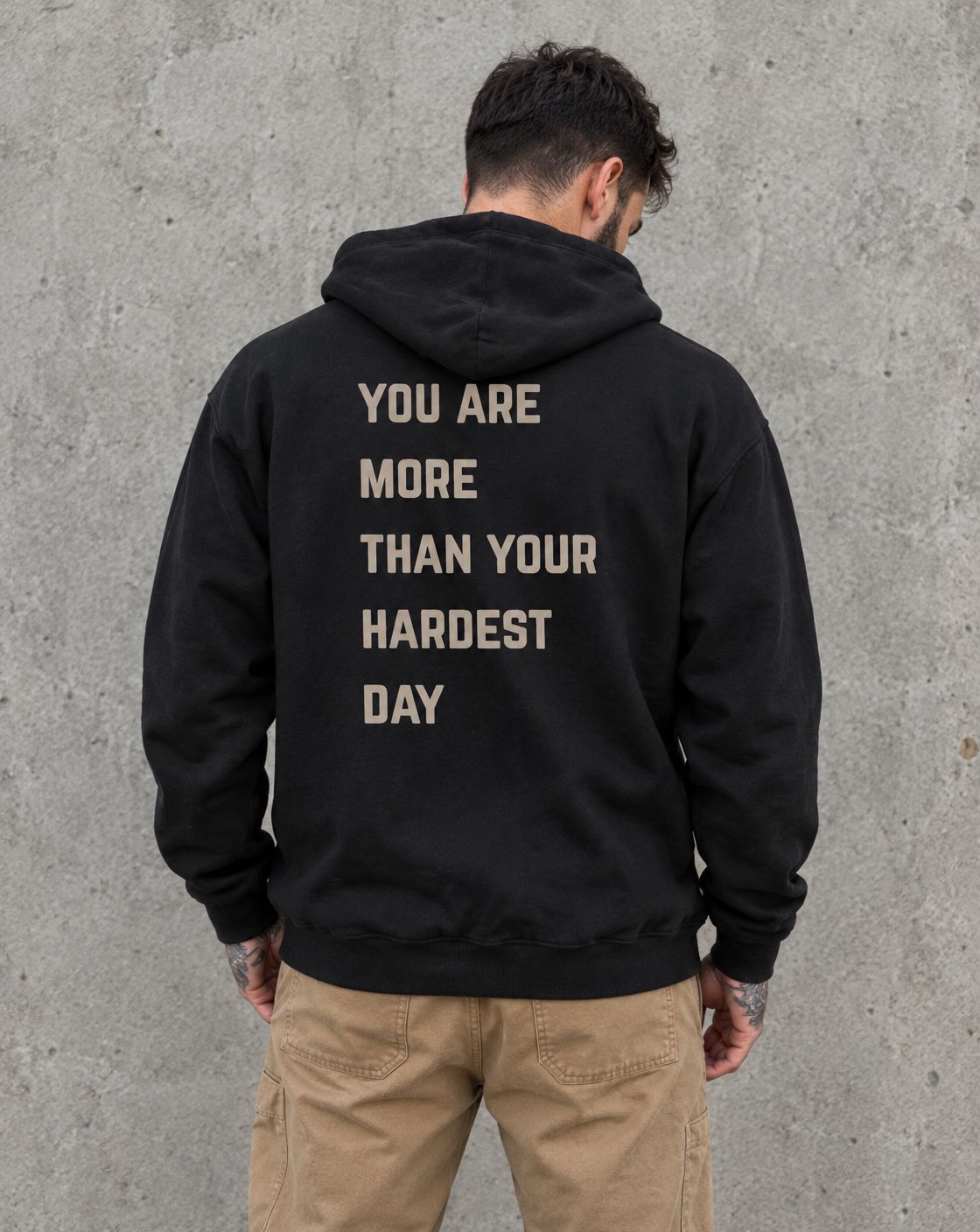 Model wearing the black You Are More Than Your Hardest Day suicide awareness zip up hoodie, back view