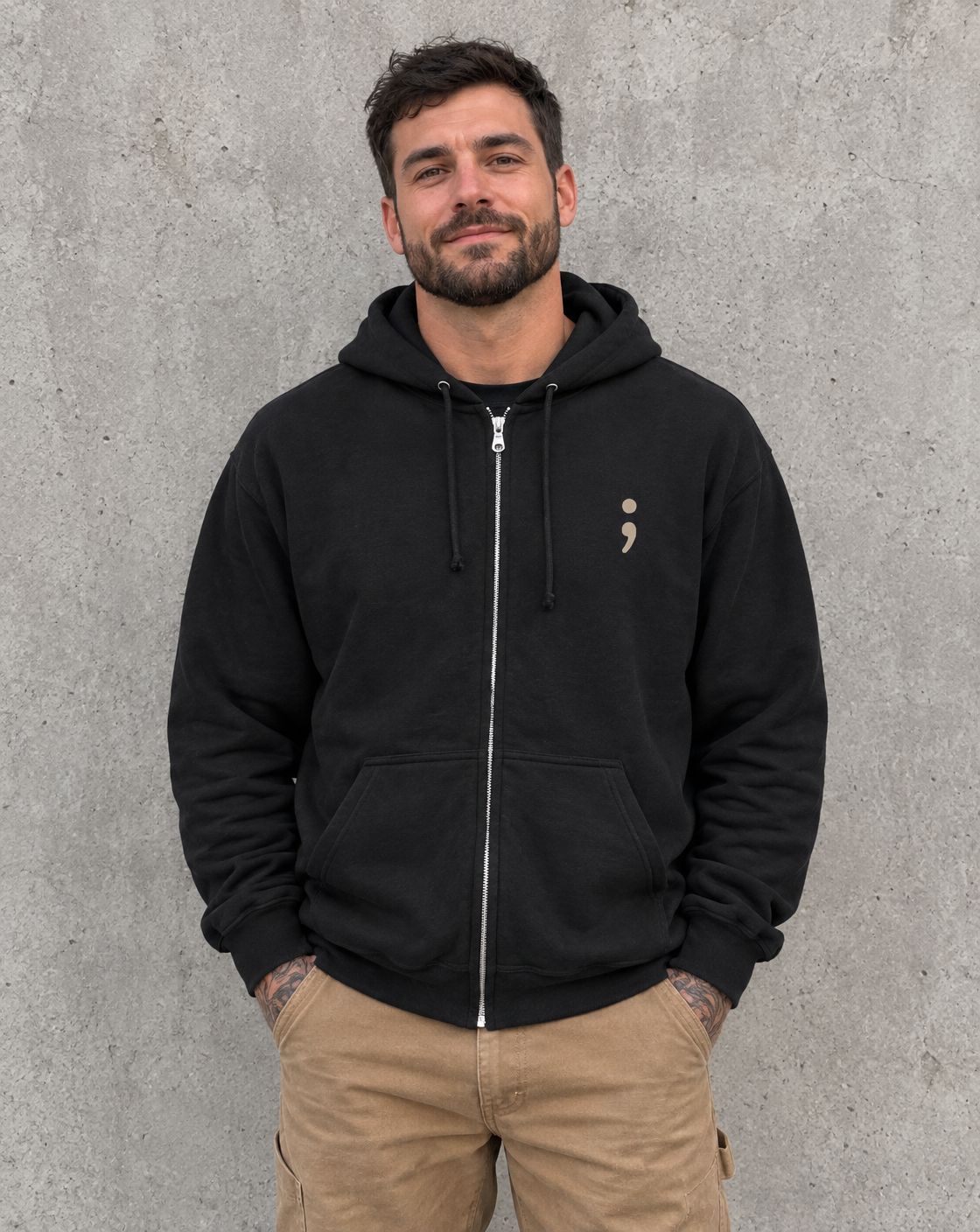 Model wearing the black You Are More Than Your Hardest Day zip up hoodie, front view with small semicolon