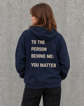 Model wearing the navy To the Person Behind Me, You Matter suicide awareness zip up hoodie, back view