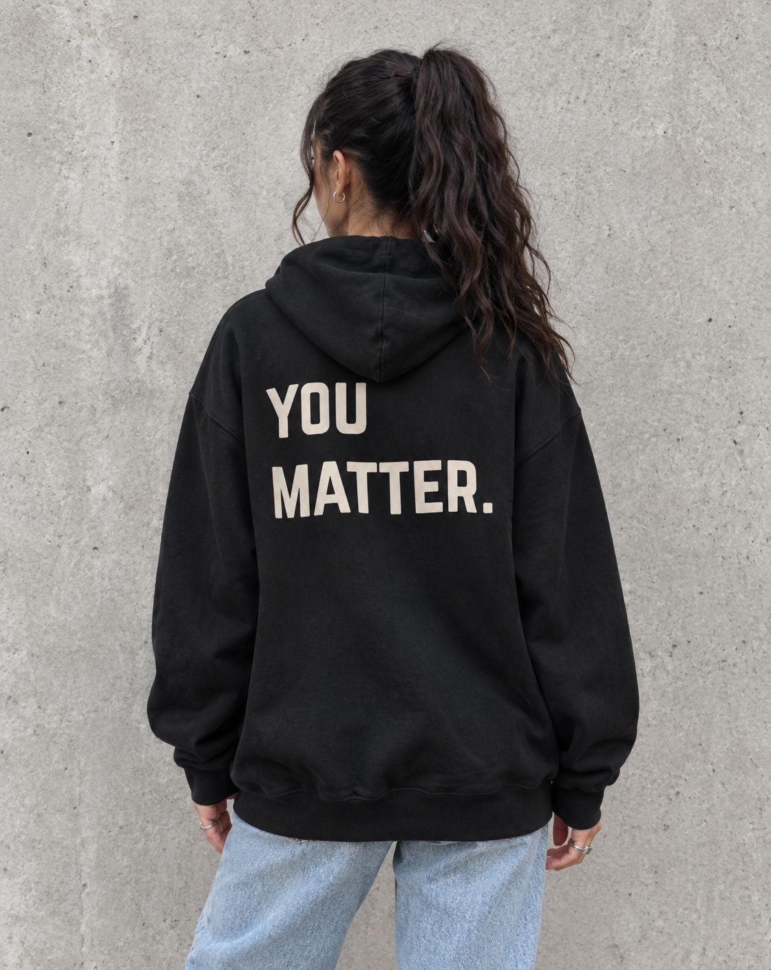 Model wearing the black You Matter. suicide awareness pullover hoodie, back view
