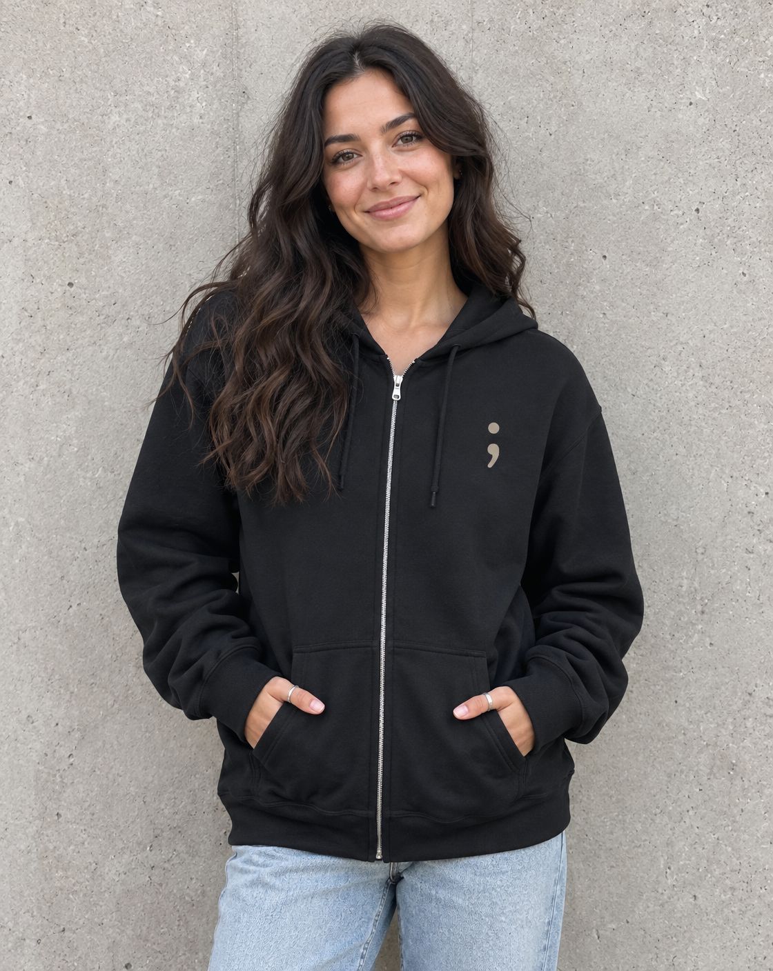 Model wearing the black I'm So Glad You're Here zip up hoodie, front view with small semicolon