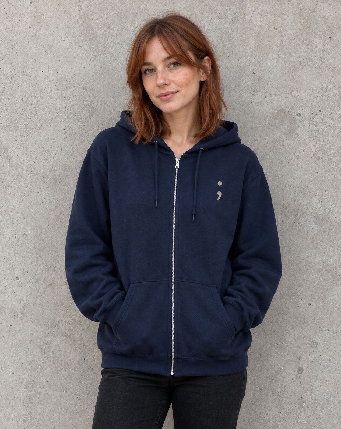 Model wearing the navy Please Stay; zip up hoodie, front view with small semicolon