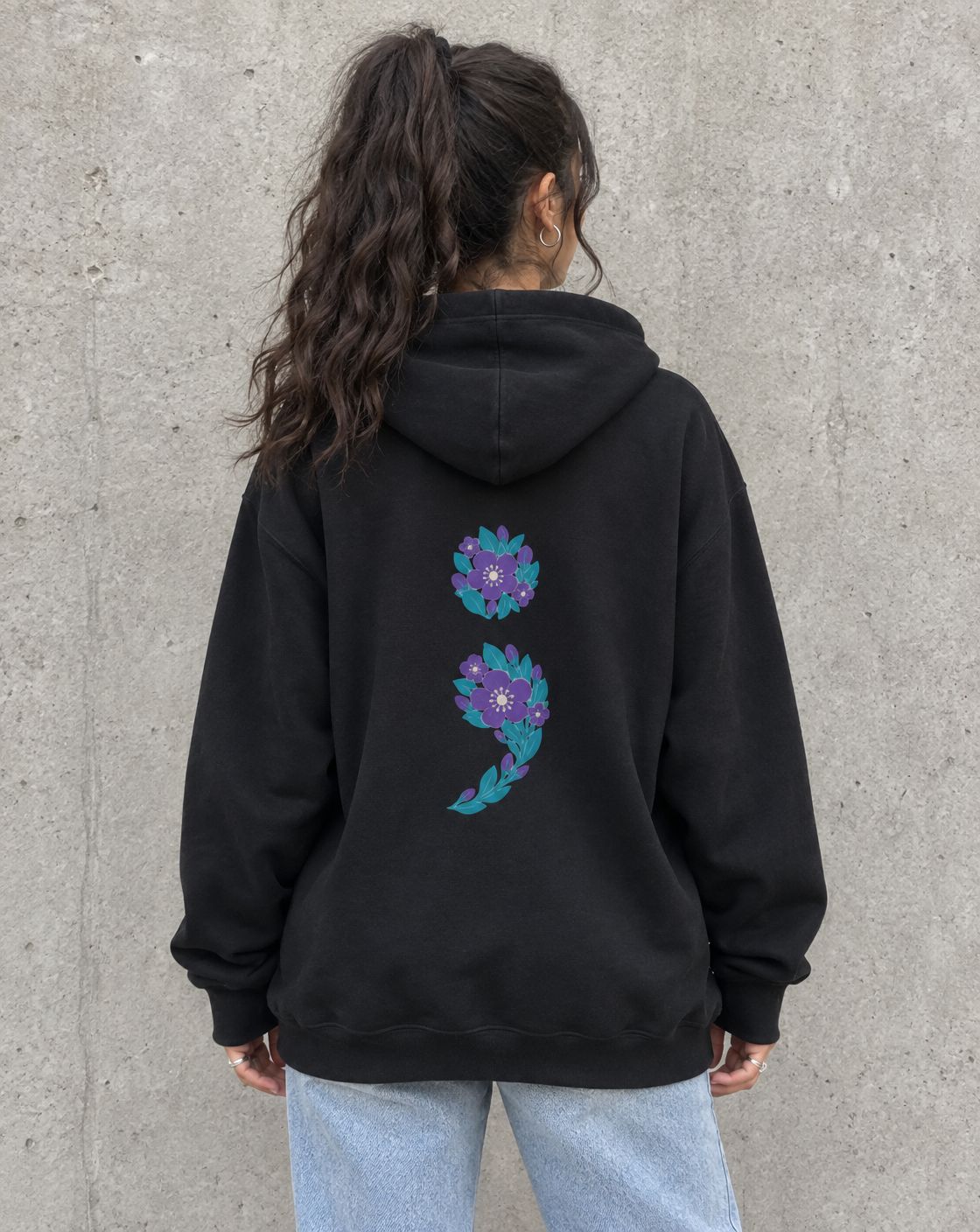 Model wearing the black floral semicolon suicide awareness pullover hoodie, back view