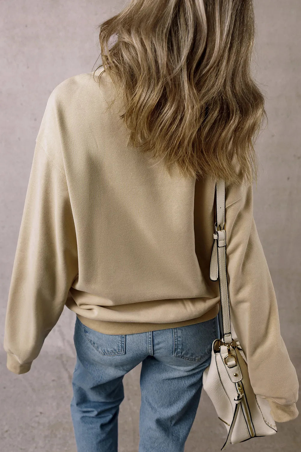 Wicked Thread Society beige long sleeve sweatshirt worn by a woman with blonde hair, back view with white bag