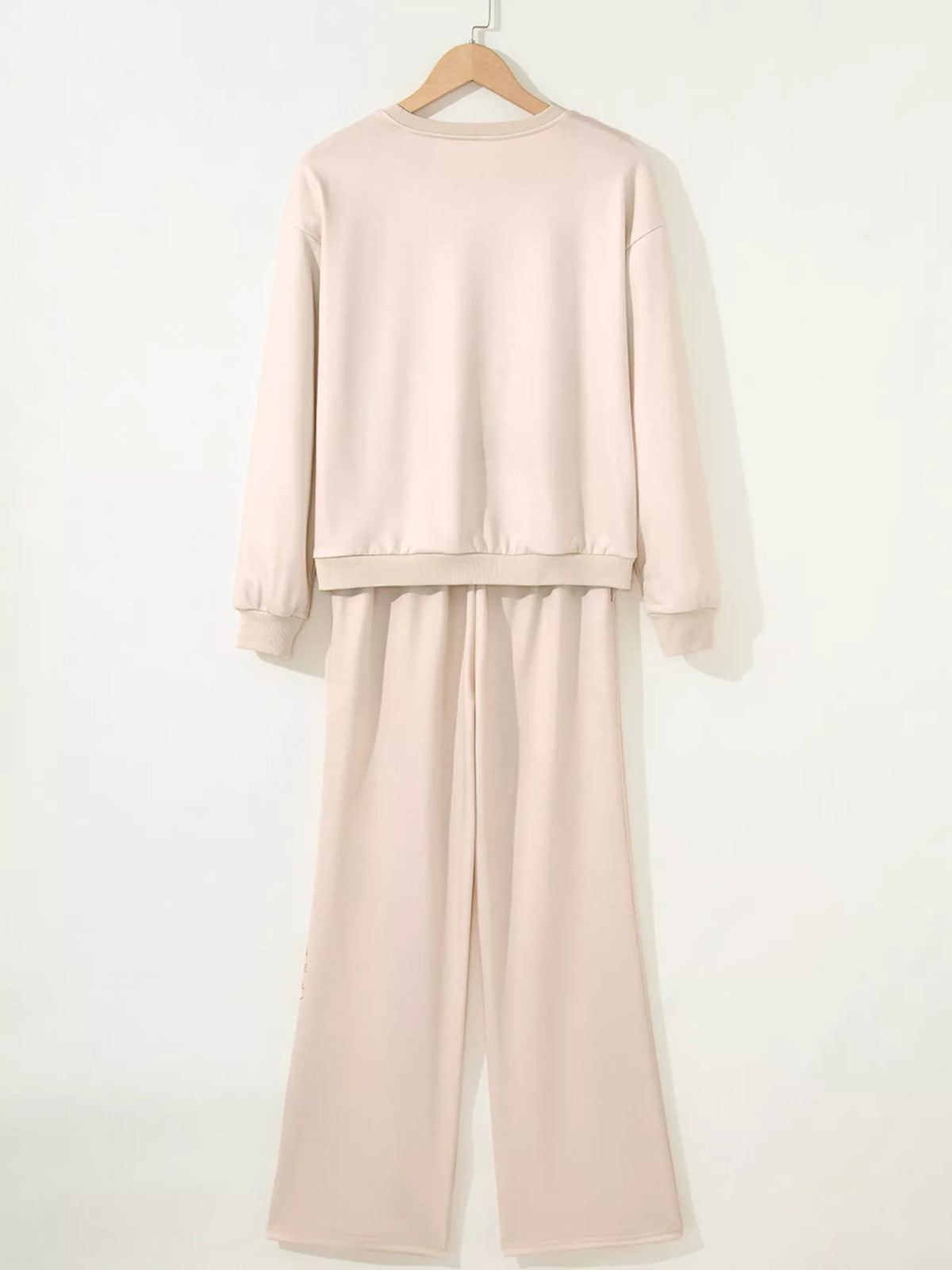 Wicked Thread Society beige long sleeve lounge set with crew neck top and wide leg pants on a wooden hanger