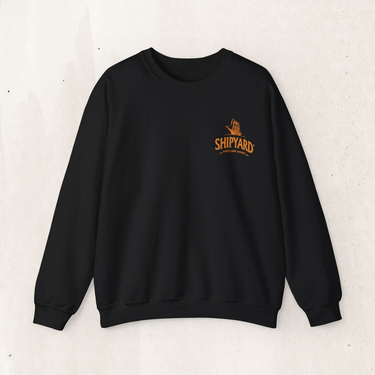 Wicked Thread Society black crewneck sweatshirt featuring a small orange Shipyard logo embroidered on the chest.