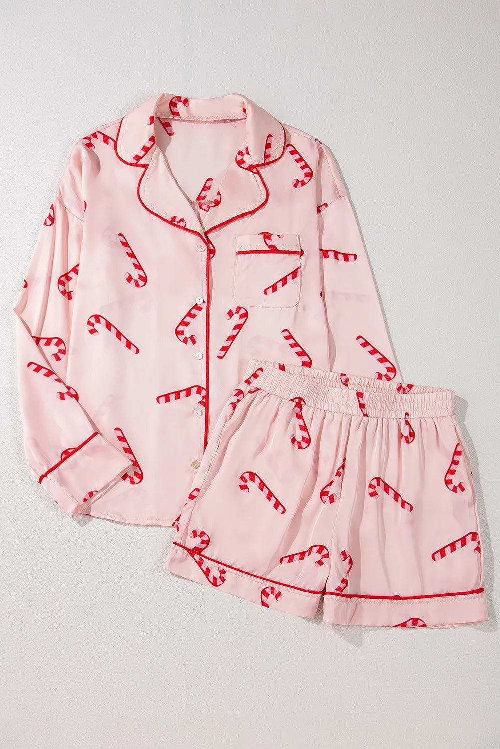 Wicked Thread Society light pink lounge set with red candy cane print, long sleeve button-up top and matching shorts.