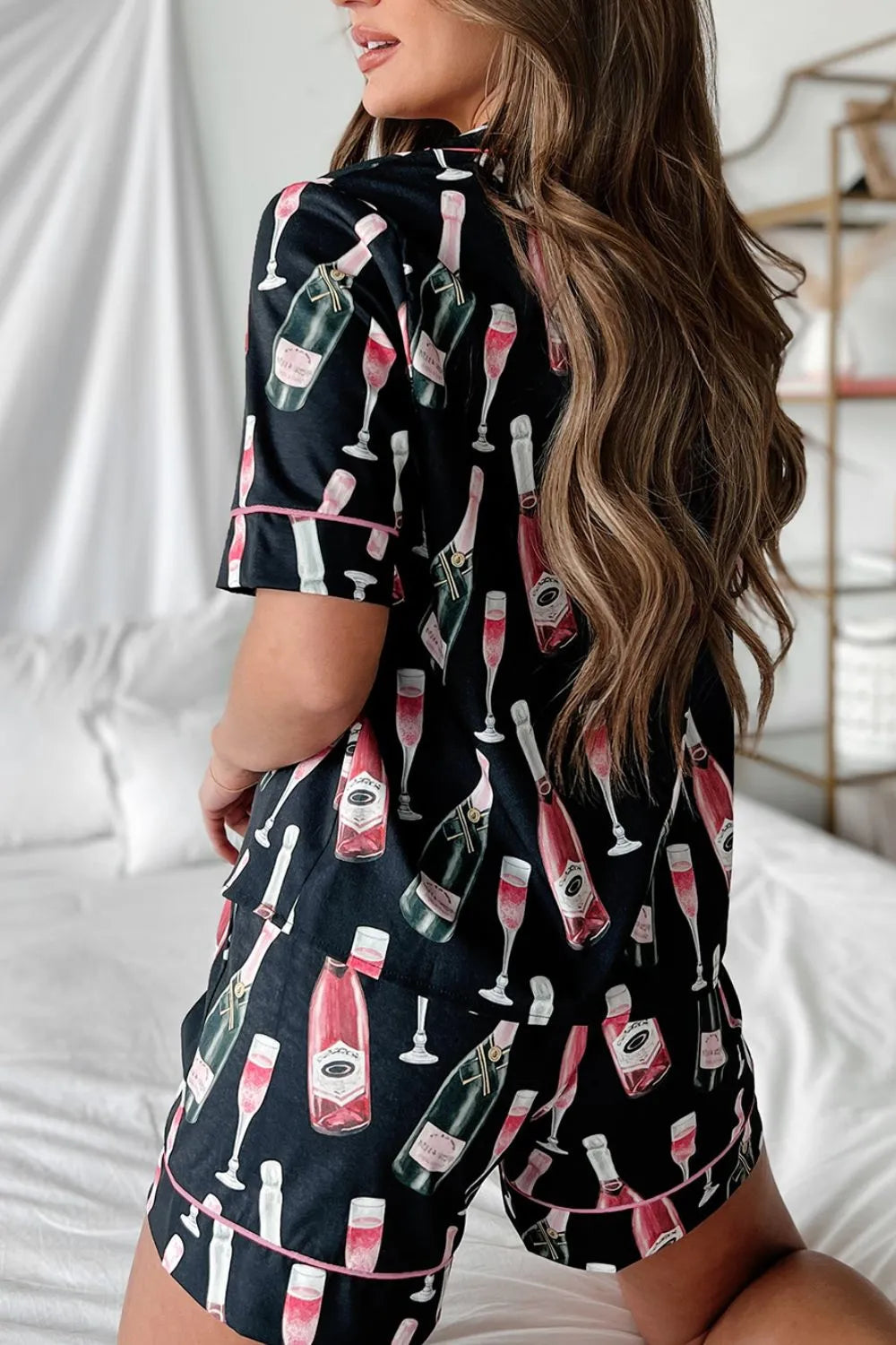 Wicked Thread Society black pajama set with champagne bottle print and pink piping, back view on a woman