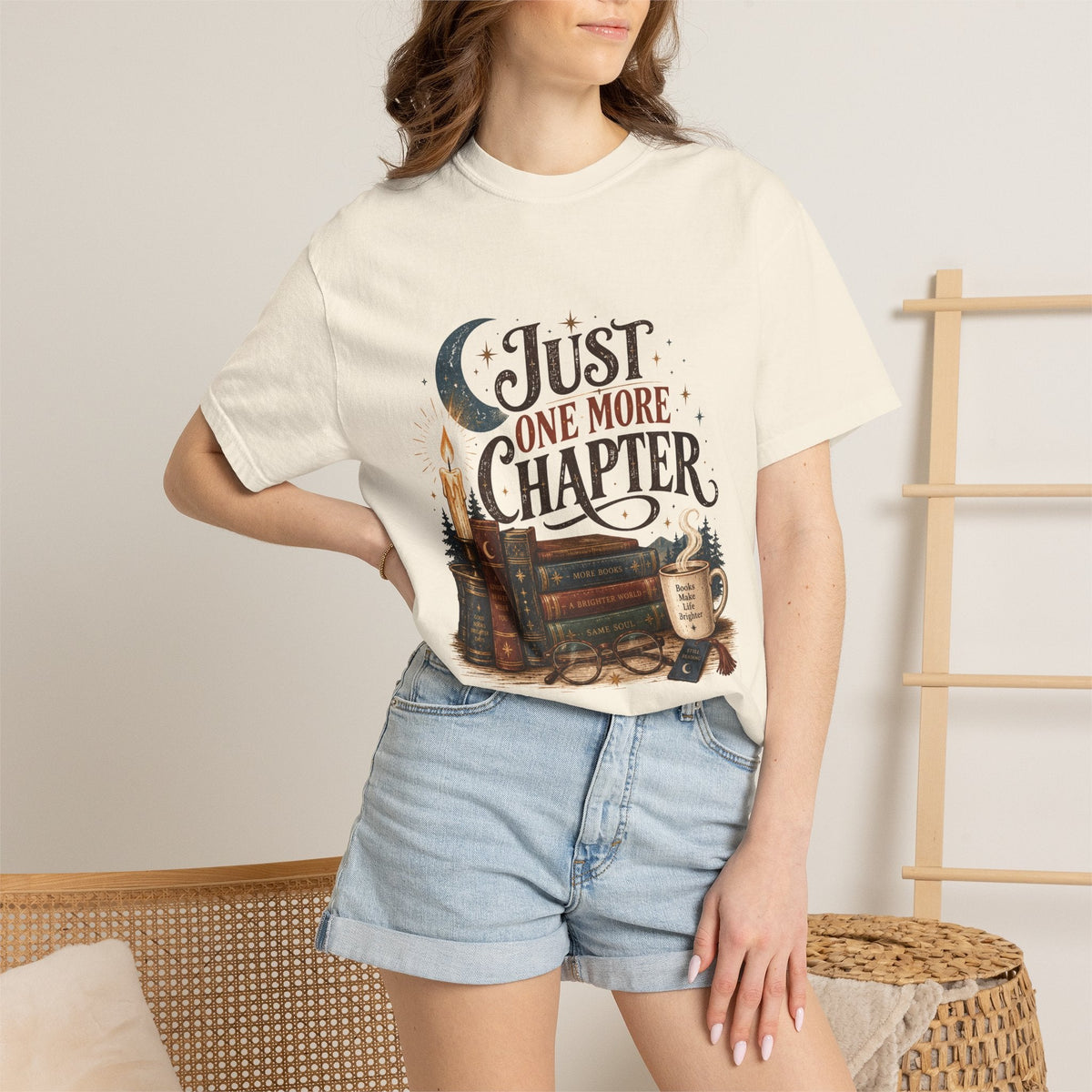 Wicked Thread Society cream graphic tee featuring vintage books, a candle, and moon illustration on a woman in shorts