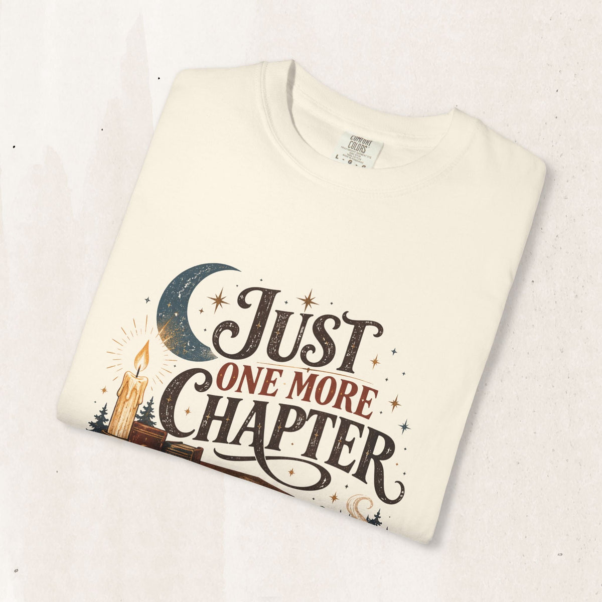 Wicked Thread Society cream graphic tee featuring a Just One More Chapter design with a candle, moon, and books.