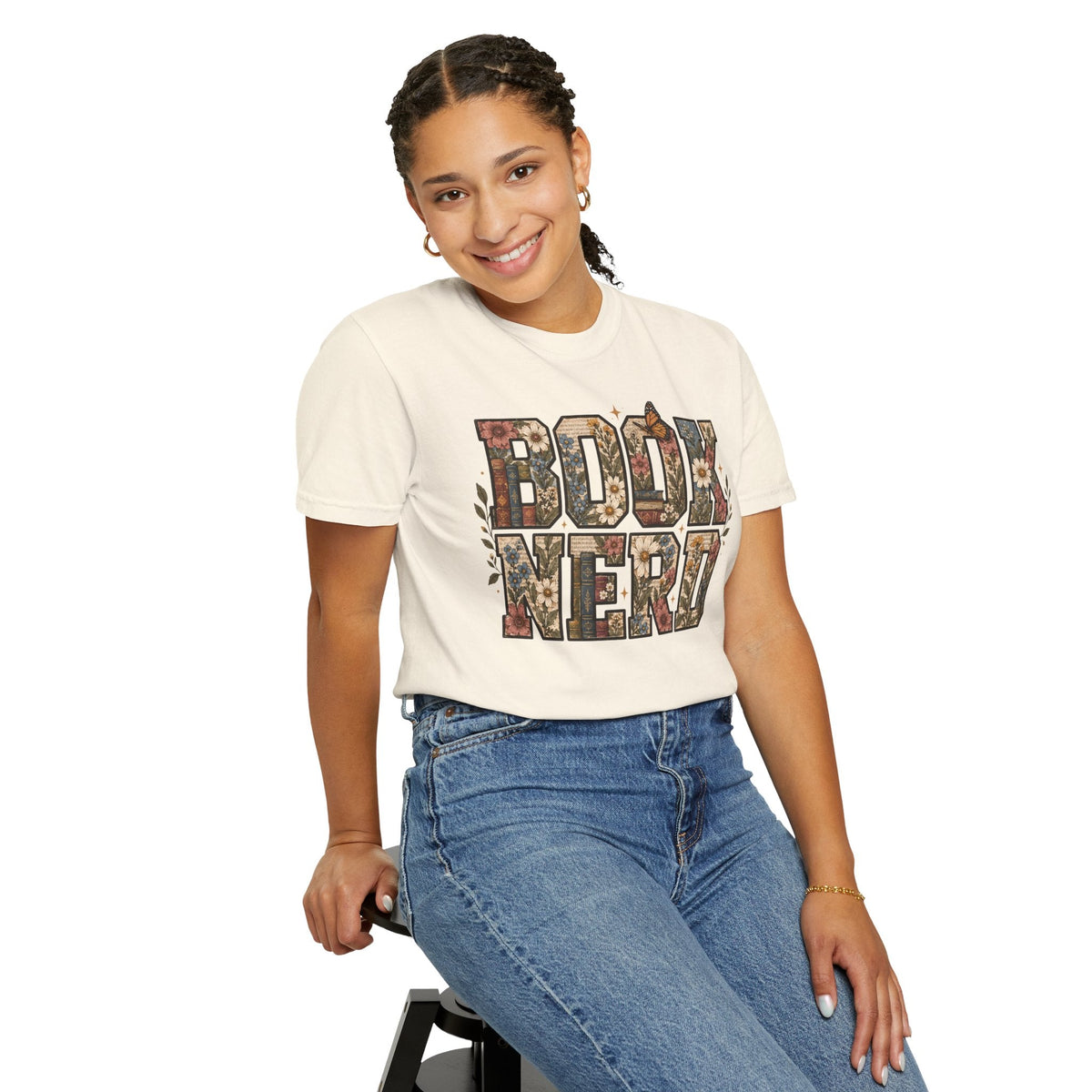 Wicked Thread Society cream graphic tee with floral BOOK NERD lettering worn by a smiling woman in blue jeans.