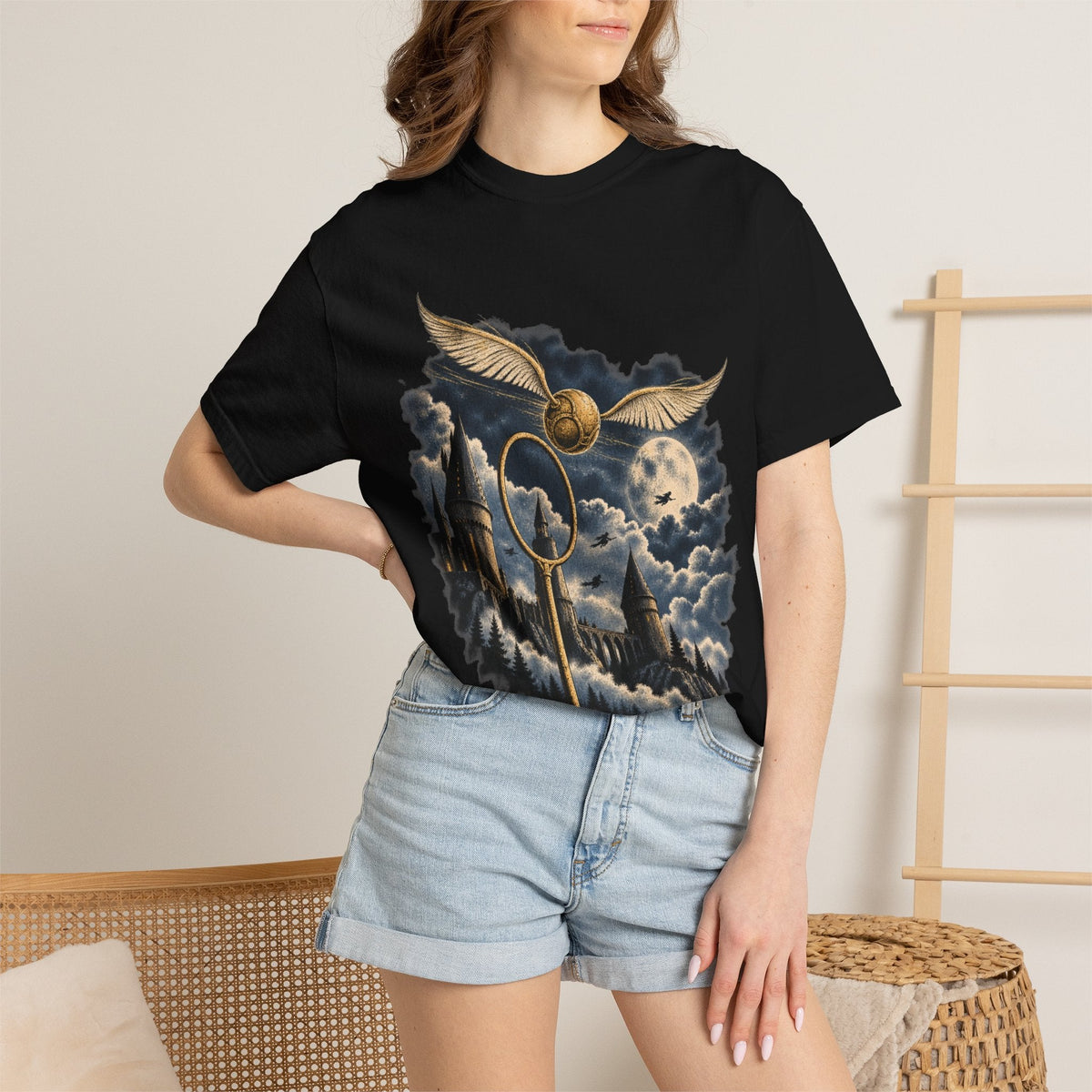 Wicked Thread Society black t-shirt featuring a Golden Snitch, Quidditch hoop, and castle graphic worn by a woman.