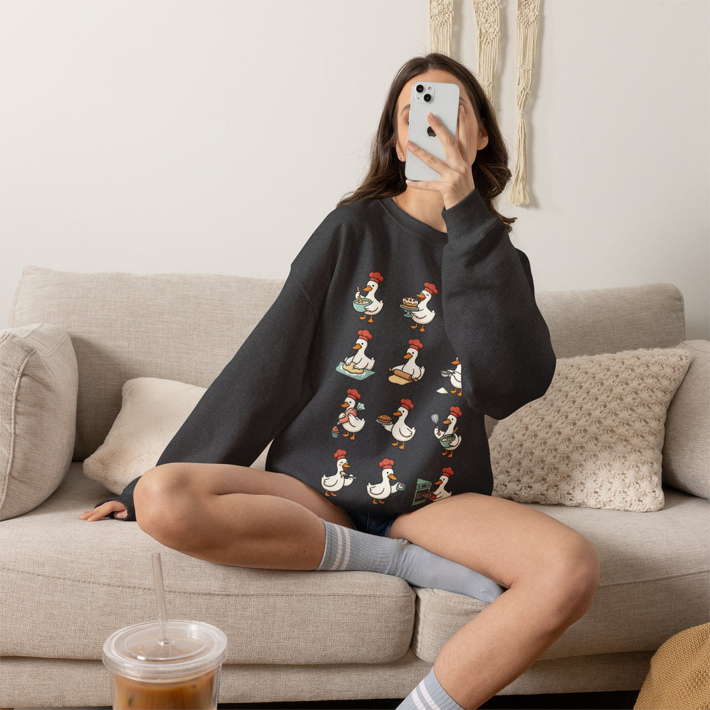Wicked Thread Society charcoal grey crewneck sweatshirt featuring a whimsical goose chef baking print on a sofa.