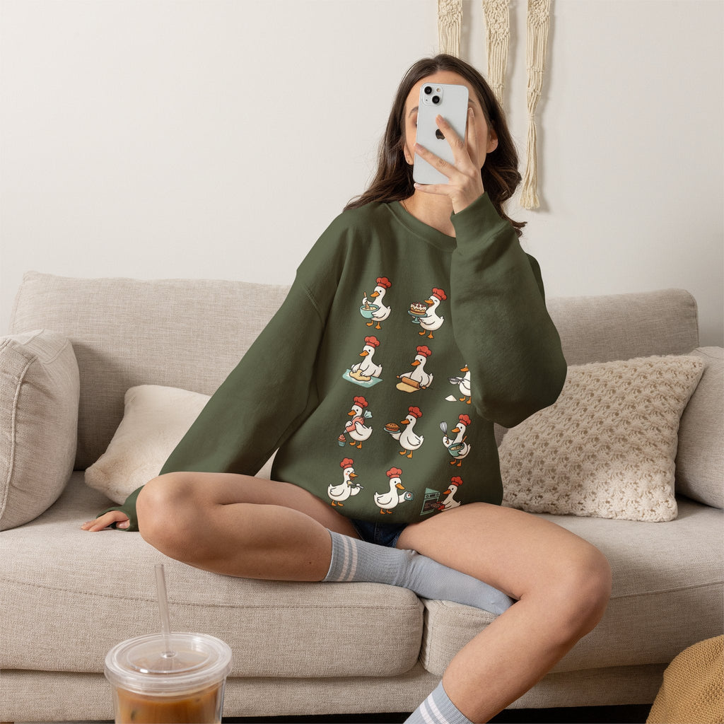 Wicked Thread Society dark green crewneck sweatshirt with a whimsical chef goose print worn by a woman on a sofa.