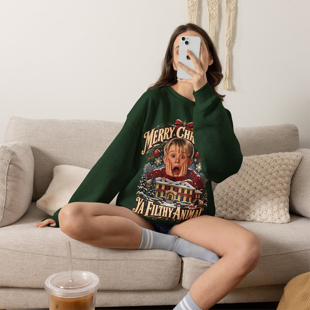 Wicked Thread Society dark green crewneck sweatshirt with a vintage Home Alone holiday graphic on a woman on a sofa