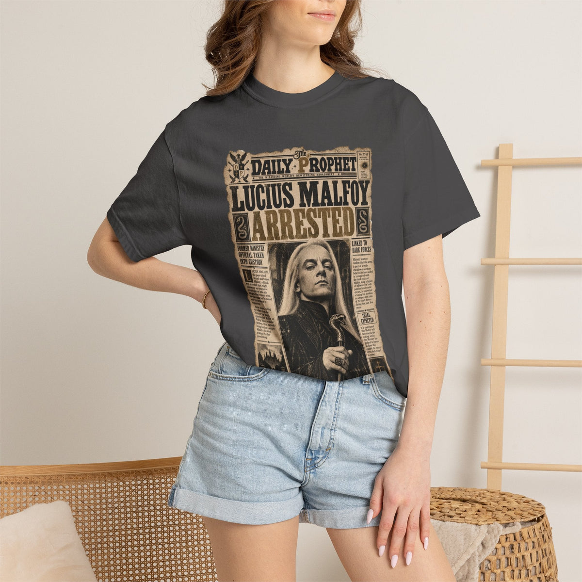 Wicked Thread Society charcoal grey graphic t-shirt featuring a vintage Daily Prophet Lucius Malfoy arrest headline.