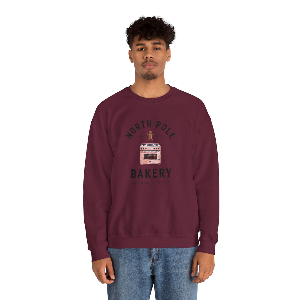 Wicked Thread Society maroon crewneck sweatshirt featuring a North Pole Bakery oven graphic worn by a young man.
