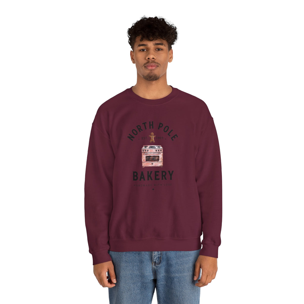 Wicked Thread Society maroon crewneck sweatshirt featuring a North Pole Bakery oven graphic worn by a young man.